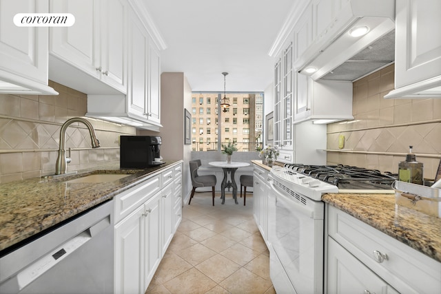 kitchen with premium range hood, a sink, stainless steel dishwasher, white gas range, and dark stone countertops