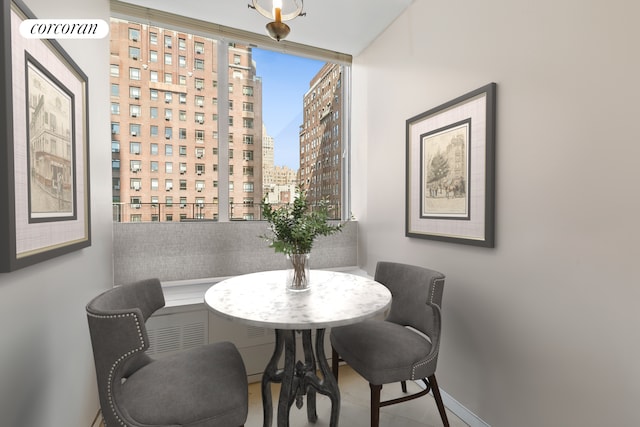 dining room featuring a view of city and baseboards