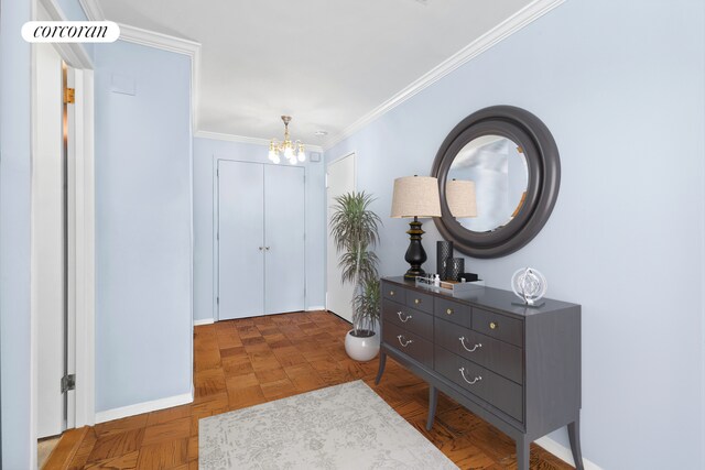 foyer entrance featuring a chandelier, baseboards, and crown molding