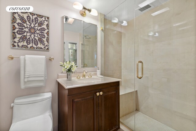 full bath featuring toilet, a shower stall, and vanity