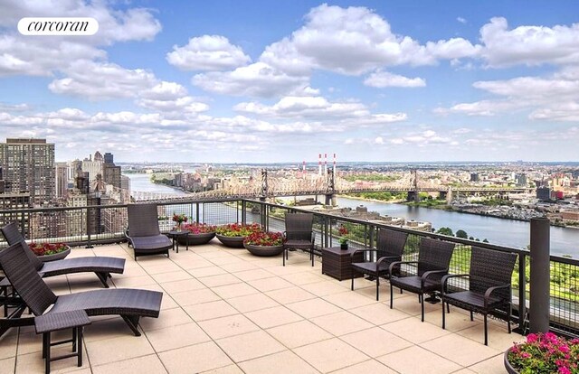 view of patio featuring a water view and a city view