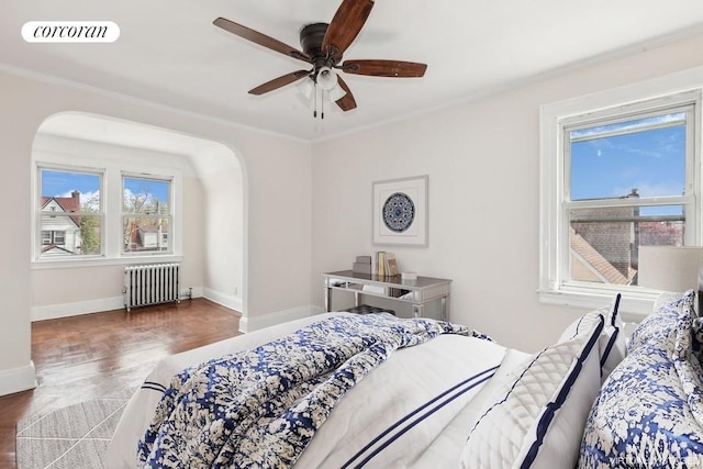 bedroom featuring ceiling fan, dark parquet flooring, radiator heating unit, and ornamental molding