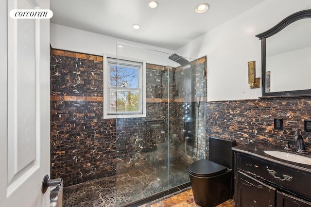 bathroom with toilet, tasteful backsplash, tile walls, tiled shower, and vanity