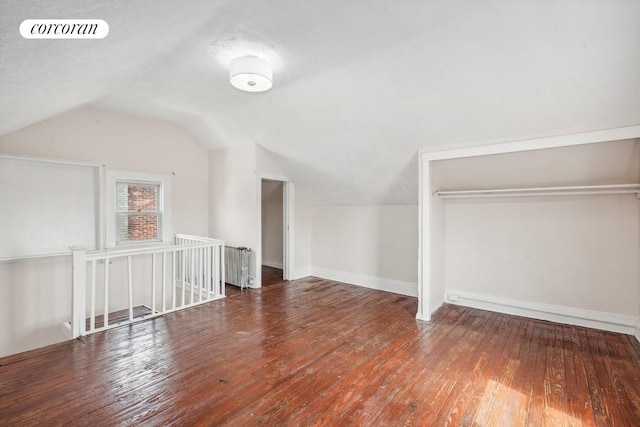 bonus room with hardwood / wood-style floors and vaulted ceiling