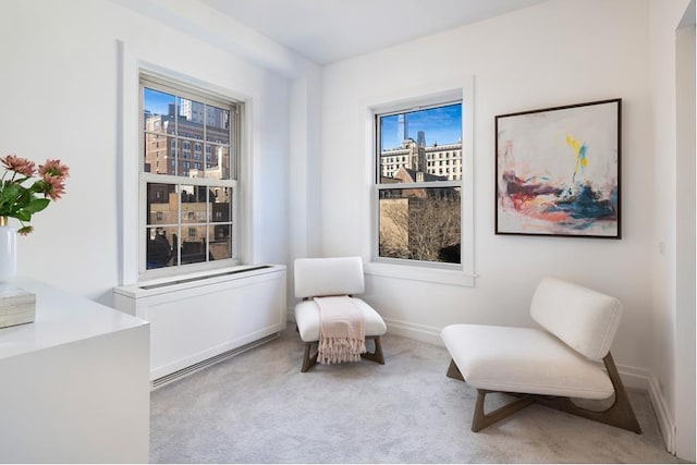 sitting room featuring a healthy amount of sunlight, baseboards, and carpet