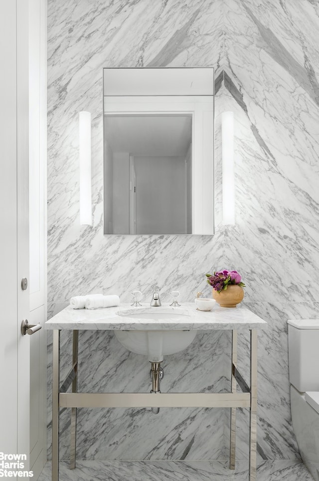 half bathroom featuring backsplash, a sink, and toilet