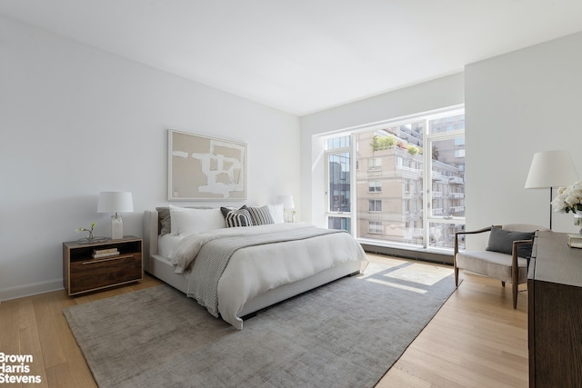 bedroom with baseboards and wood finished floors