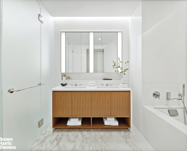 full bathroom featuring marble finish floor, a sink, a bath, and double vanity