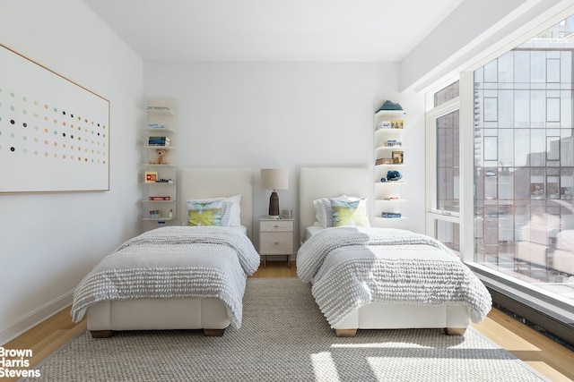 bedroom with baseboards and wood finished floors