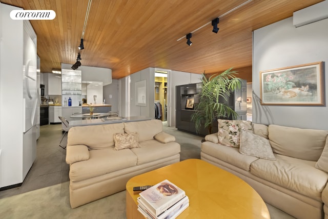 living area with visible vents, wood ceiling, rail lighting, concrete flooring, and an AC wall unit