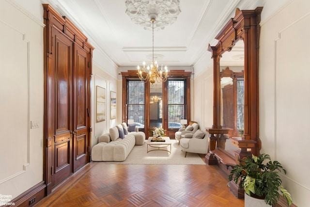 interior space with a notable chandelier, a decorative wall, and ornamental molding