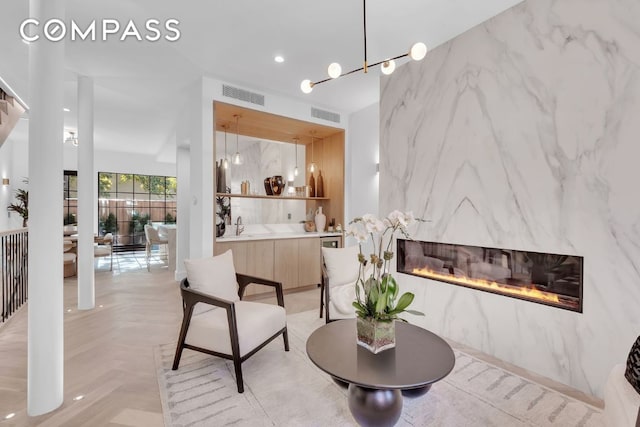 living area with light parquet floors, a premium fireplace, and sink