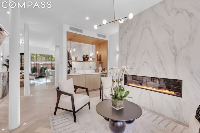 interior space featuring light parquet flooring, a large fireplace, and sink