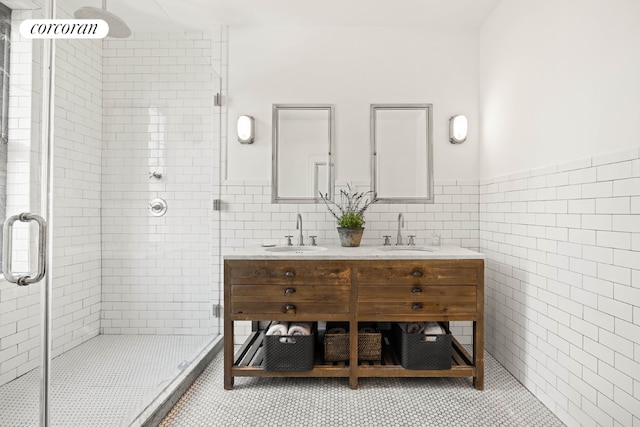 bathroom featuring tile patterned floors, a shower with shower door, tile walls, and vanity