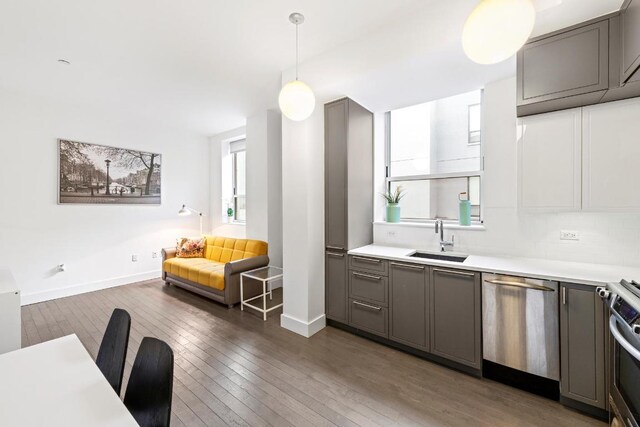 kitchen featuring gray cabinetry, hanging light fixtures, and stainless steel dishwasher