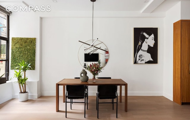 dining area featuring beamed ceiling and wood-type flooring