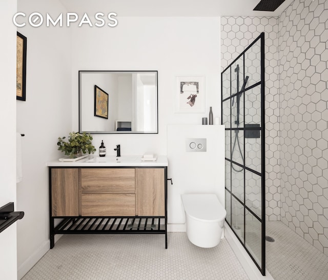 bathroom featuring tile patterned flooring, a tile shower, and vanity