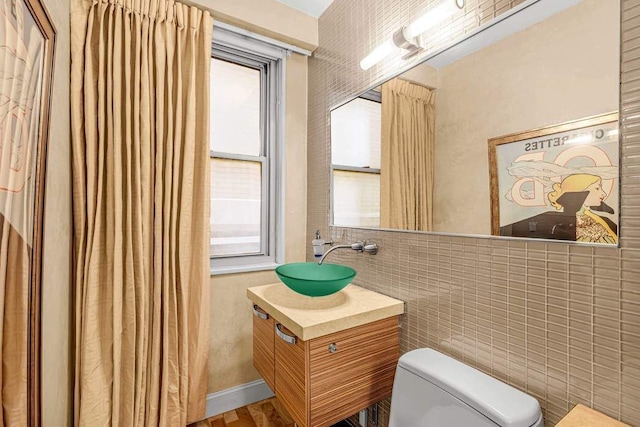 300 E 74th St Unit 3C, New York City, NY 10021 - bathroom featuring toilet, vanity, and tile walls