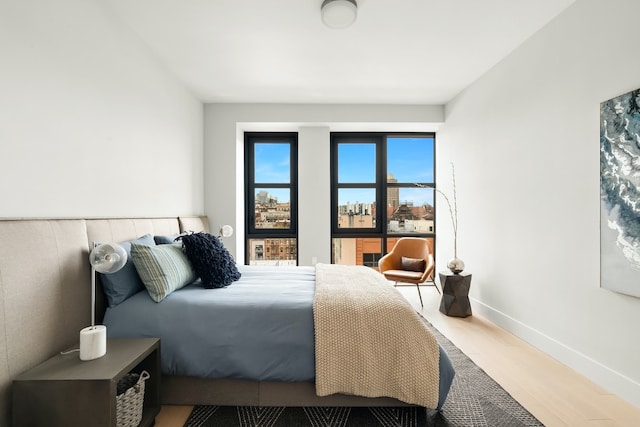 bedroom with wood finished floors and baseboards