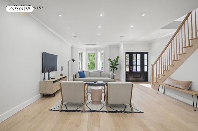 living room featuring light wood-type flooring and ornamental molding