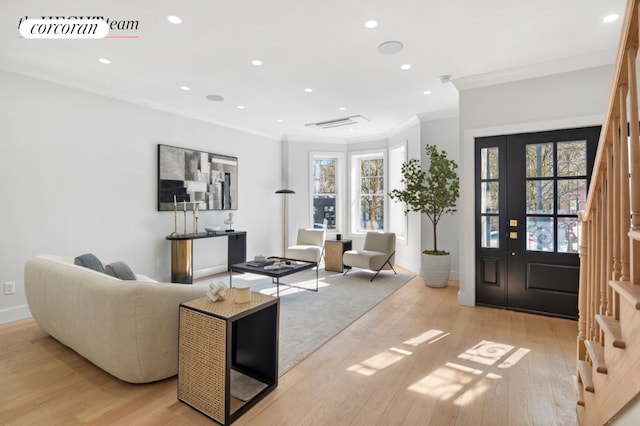 living area featuring visible vents, light wood-style flooring, ornamental molding, stairs, and recessed lighting