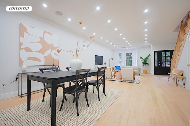 dining space with light wood-type flooring and crown molding