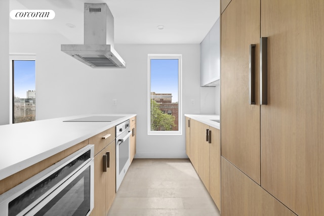 625 Rogers Ave Unit 6C, New York City, NY 11225 - kitchen featuring island exhaust hood, black electric stovetop, light countertops, modern cabinets, and stainless steel oven
