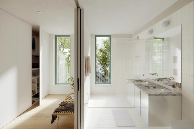 bathroom featuring double sink and a shower