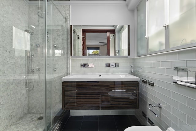 bathroom featuring a shower with door, vanity, tile patterned flooring, and tile walls