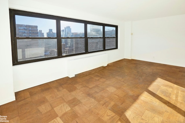 spare room featuring a view of city and baseboards