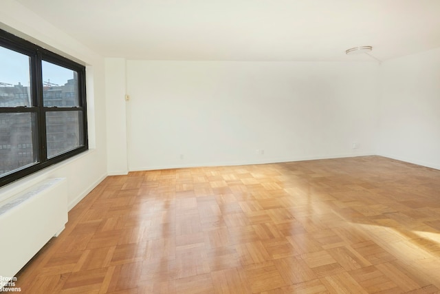 spare room with radiator and baseboards