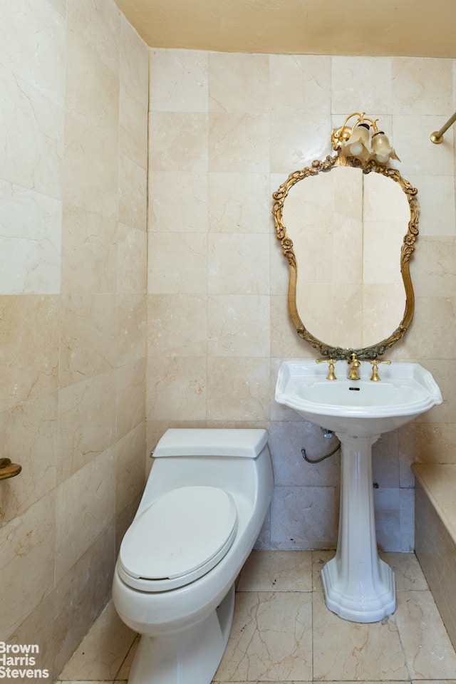 bathroom with toilet and tile walls