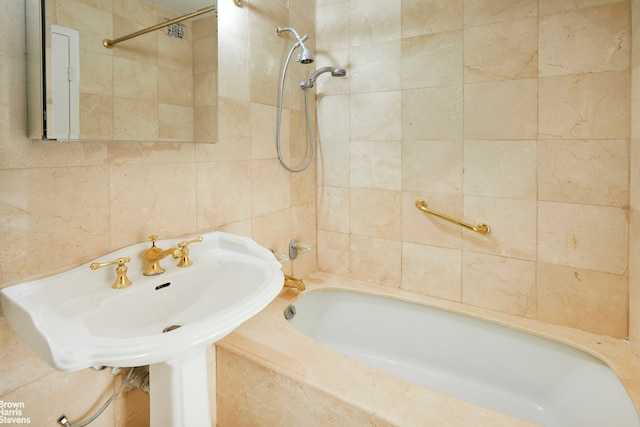 bathroom featuring a sink, tile walls, and shower / washtub combination