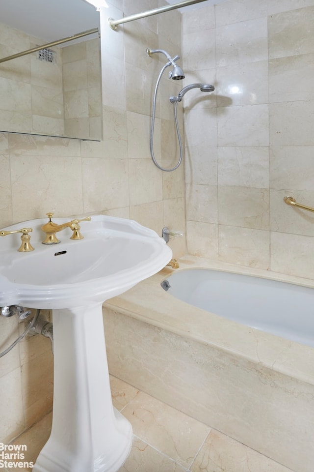 full bath with backsplash, tile walls, shower / bathing tub combination, and a sink