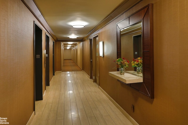 hall with baseboards and light wood-style floors