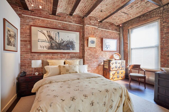 bedroom featuring baseboards, brick ceiling, and brick wall