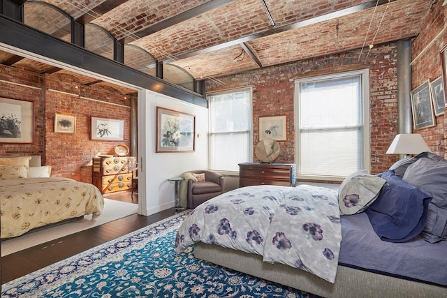 bedroom featuring brick ceiling, wood finished floors, baseboards, and brick wall