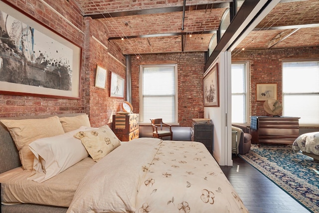 bedroom featuring brick ceiling, brick wall, a towering ceiling, and dark wood-style flooring