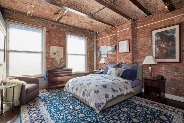 bedroom featuring brick ceiling, wood finished floors, baseboards, and brick wall