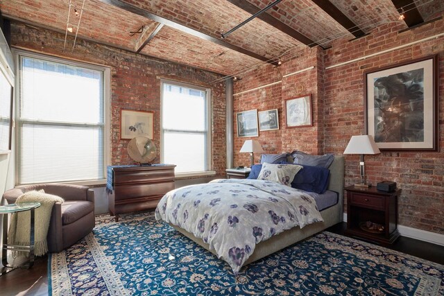 bedroom with brick ceiling, brick wall, and wood finished floors