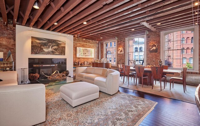 living room featuring brick wall and wood-type flooring