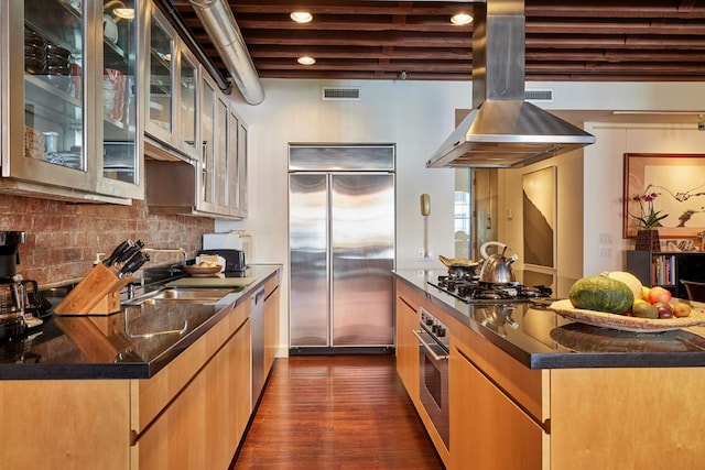 kitchen featuring dark wood-style floors, visible vents, island exhaust hood, stainless steel appliances, and decorative backsplash