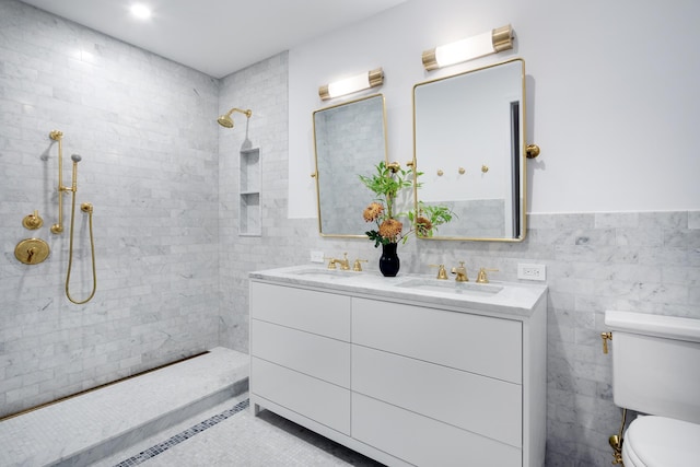 bathroom featuring a sink, toilet, tile walls, and a tile shower