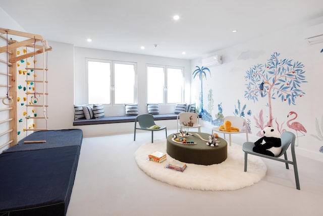 sitting room featuring a wall mounted air conditioner and recessed lighting