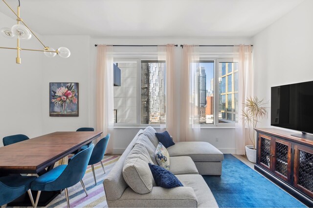 living room featuring baseboards and an inviting chandelier