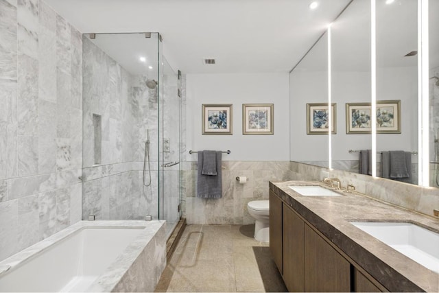 full bathroom featuring toilet, separate shower and tub, tile walls, vanity, and tile patterned flooring