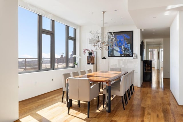 dining space with hardwood / wood-style floors and a chandelier