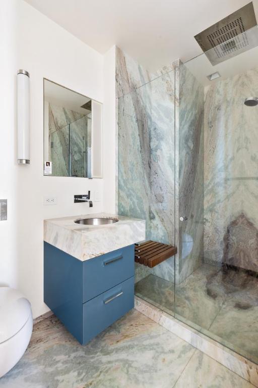 bathroom featuring vanity, a shower, and toilet