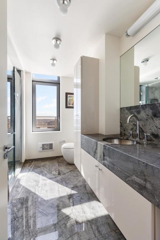 bathroom featuring vanity, decorative backsplash, and toilet