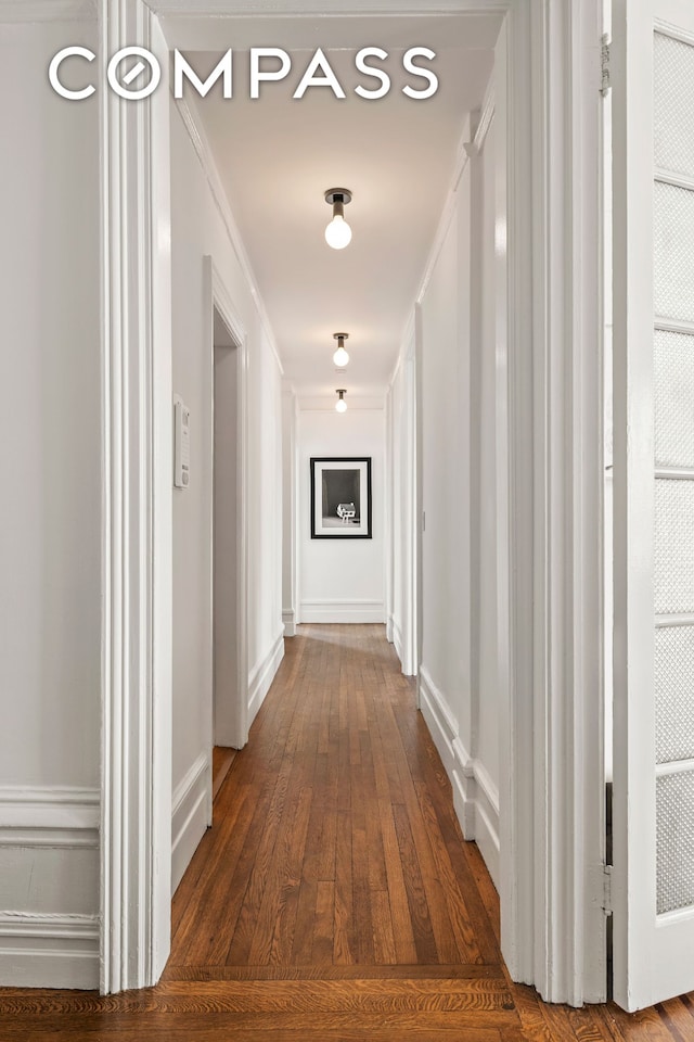 hall with dark wood-style floors and baseboards